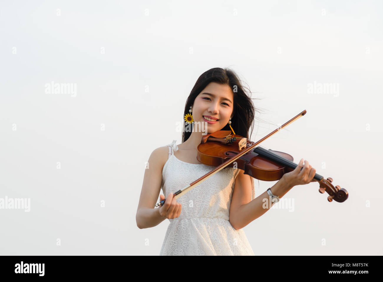 Femme heureuse à jouer du violon sur la plage. Banque D'Images