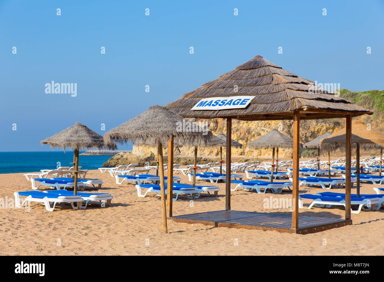 Des parasols de plage en osier bleu et des lits de plage en mer Banque D'Images