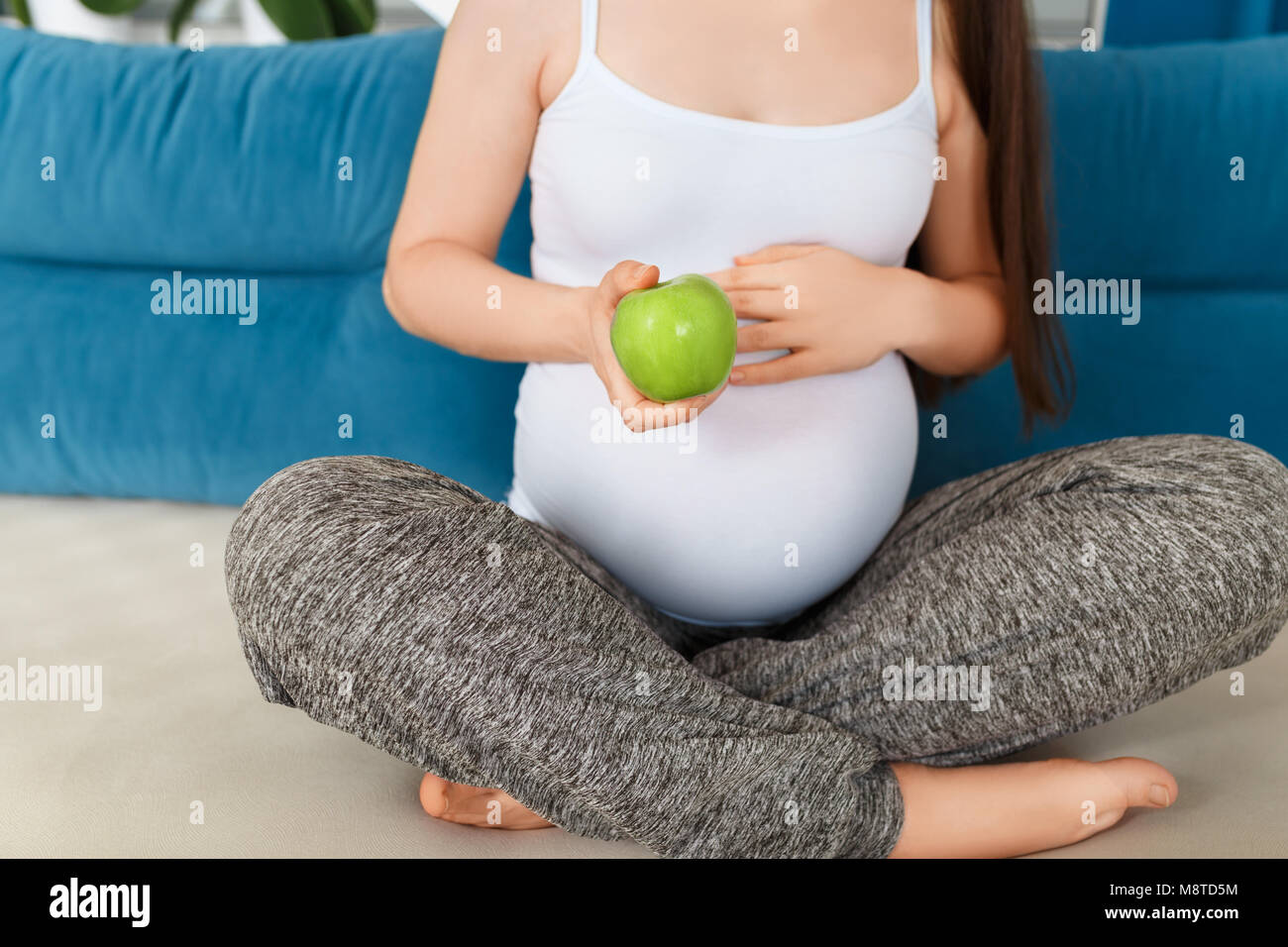Pregnant woman holding apple Banque D'Images