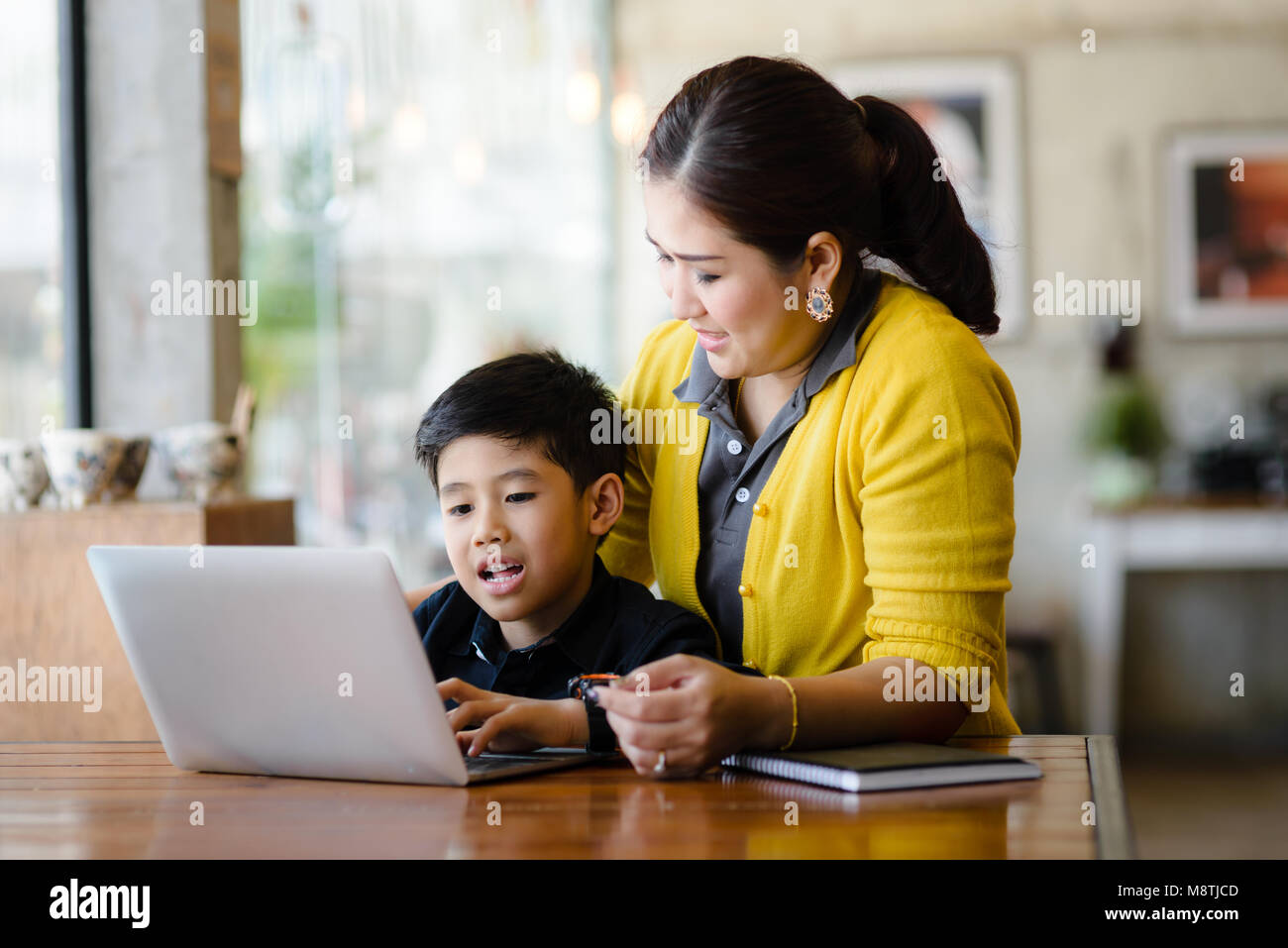 Happy Asian mère et son fils à l'aide d'ordinateur portable à la maison. Banque D'Images