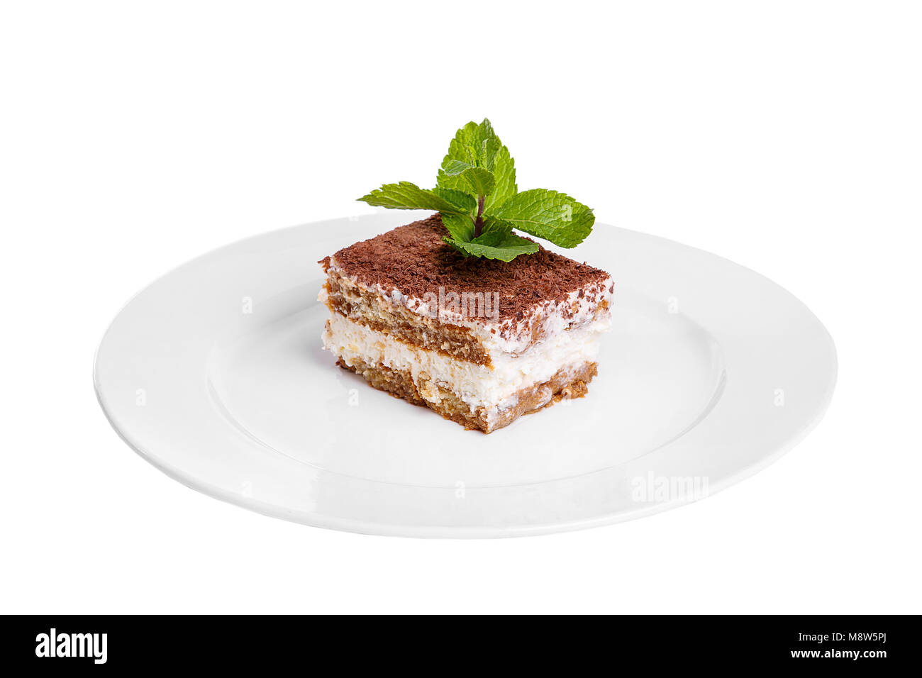 Morceau rectangulaire de Tiramisu avec une feuille de menthe sur une plaque blanche. isolé sur fond blanc. Dessert pour un menu dans un café, restaurant, café sh Banque D'Images