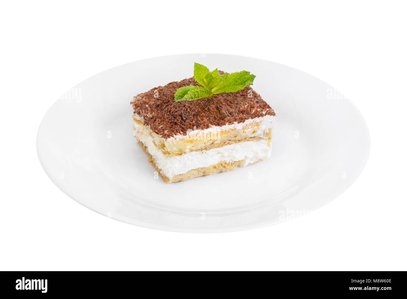 Morceau rectangulaire de Tiramisu avec une feuille de menthe sur une plaque blanche. isolé sur fond blanc. Dessert pour un menu dans un café, restaurant, café sh Banque D'Images