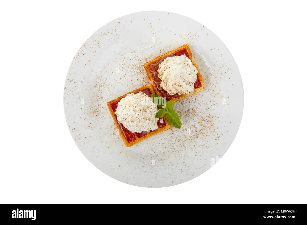 Gaufrettes épais avec berry jam rouge et crème fouettée dessus avec une feuille de menthe sur une plaque sur un arrière-plan blanc isolé. Dessert pour un menu dans un café, re Banque D'Images