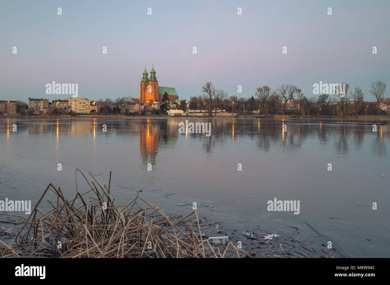 Gniezno, Pologne ; soir vue de la cathédrale gothique sur le lac gelé. L'hiver. Banque D'Images