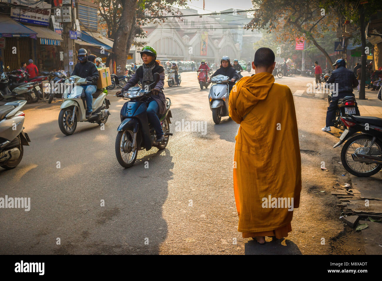 Scène de rue du Vietnam, vue à l'aube d'un jeune moine bouddhiste faisant son chemin à travers le vieux quartier historique dans le centre de Hanoi, Vietnam Banque D'Images