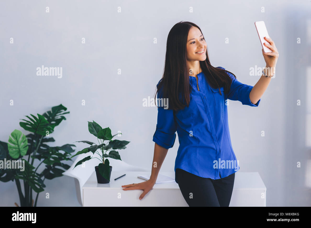 Jeune femme séduisante selfies faire à son lieu de travail Banque D'Images