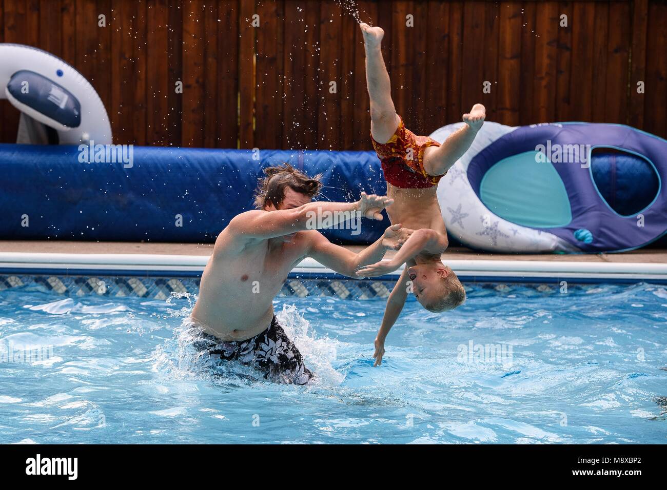 Deux garçons jouant dans la piscine un jour d'été Banque D'Images