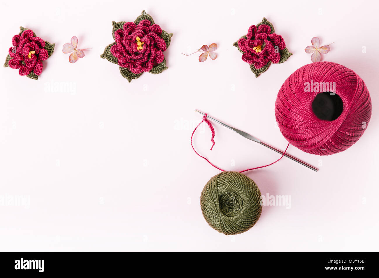 Le rouleau de fil de coton vert et violet et rose au crochet crochet, fleurs, décoration, ornement, Bastet sur fond blanc. Le concept de croch Banque D'Images