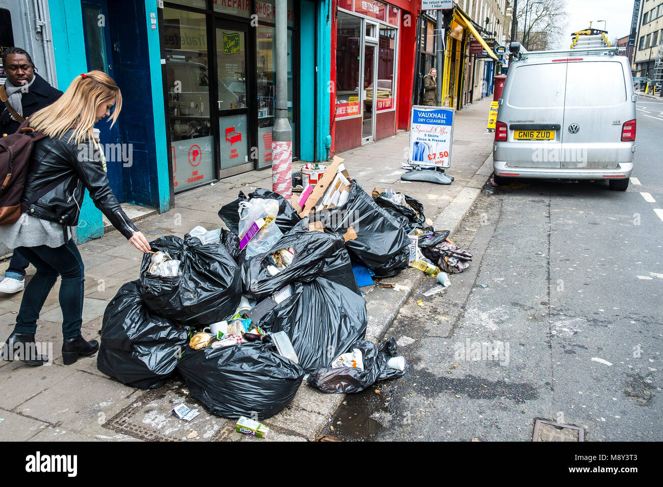 Un tas d'ordures sacs noirs entassés sur un trottoir à Lambeth Londres. Banque D'Images