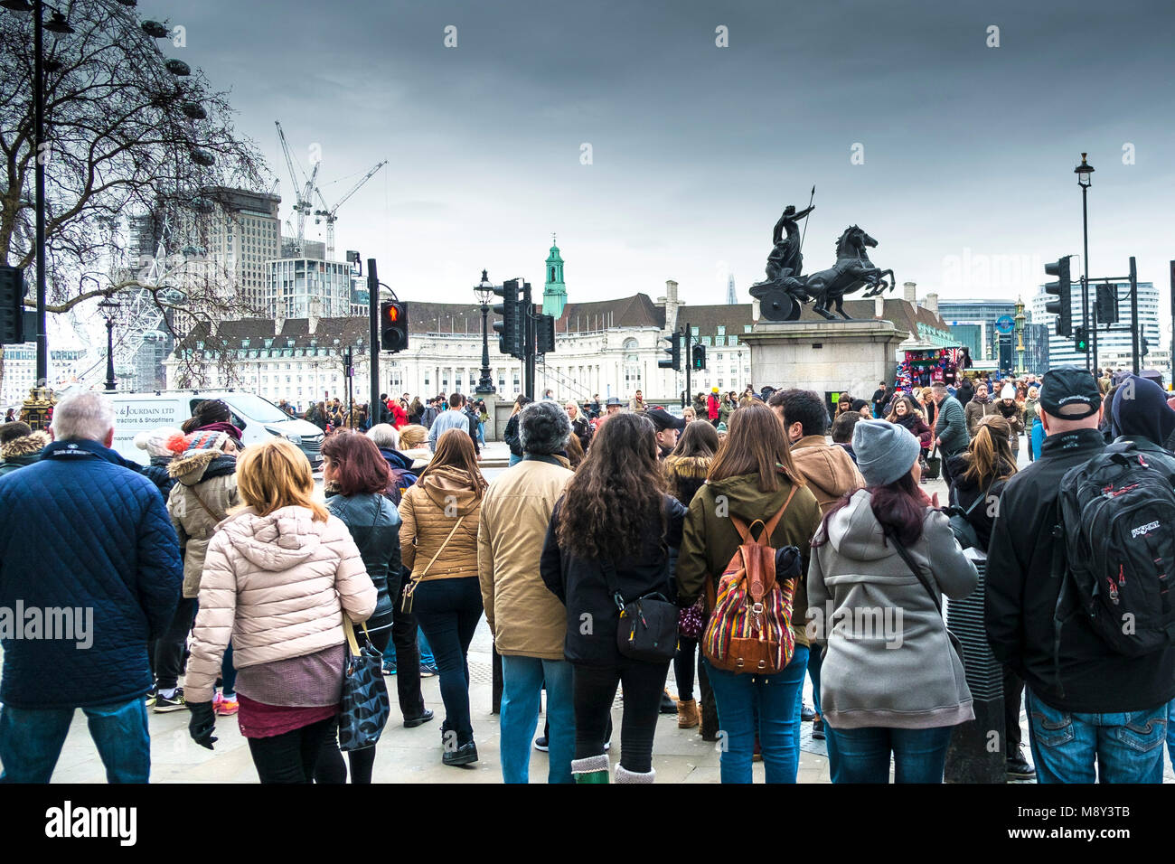 Les touristes en attente de traverser la route près de Westminster Bridge à Londres. Banque D'Images