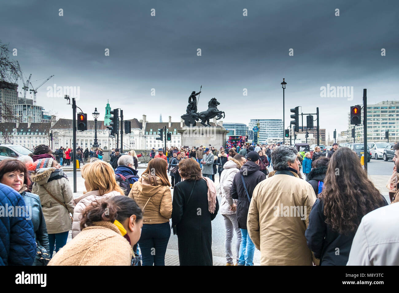 Les touristes en attente de traverser la route près de Westminster Bridge à Londres. Banque D'Images