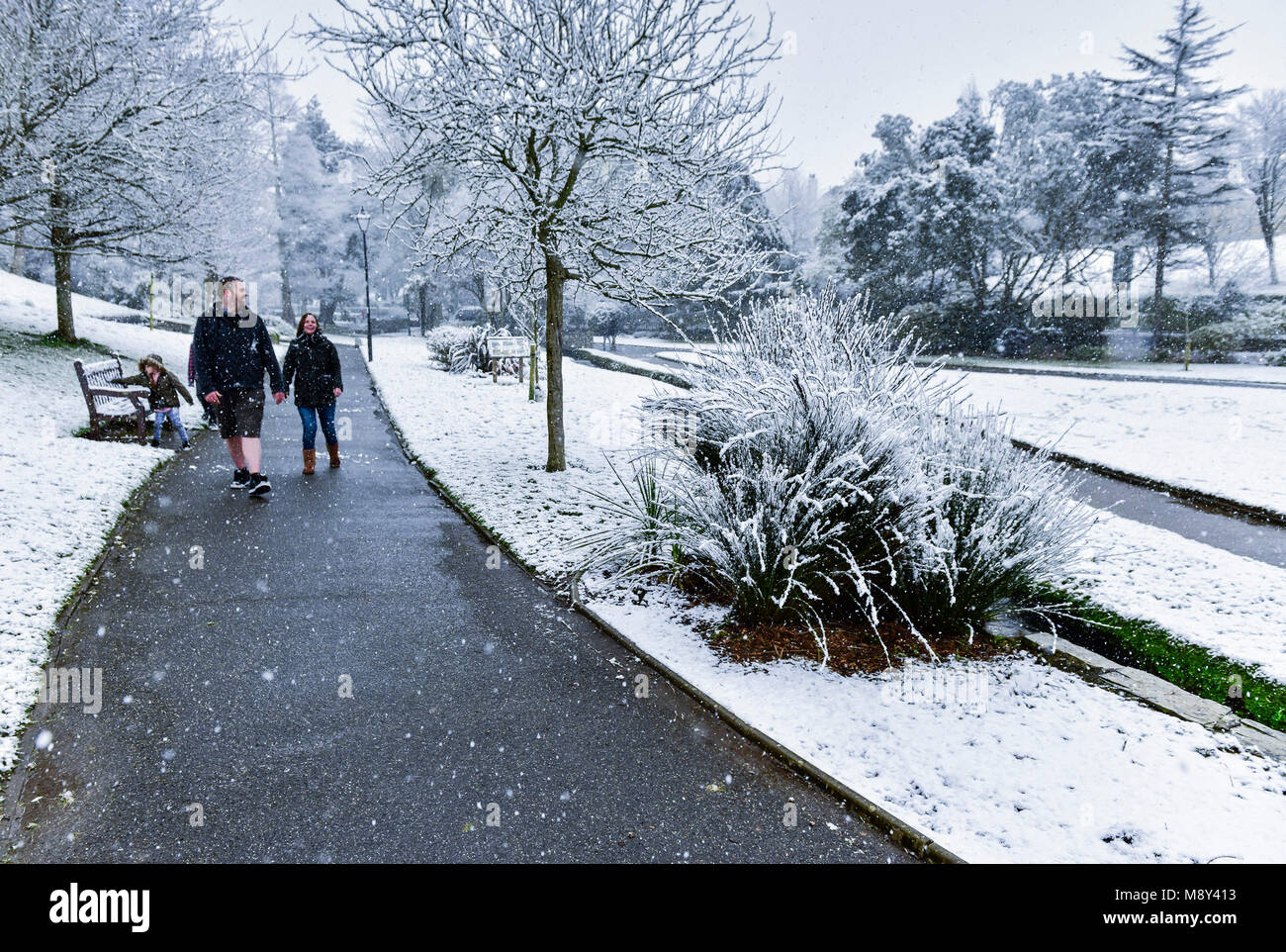Une famille profiter de la neige dans les jardins de Trenance Newquay Cornwall. Banque D'Images