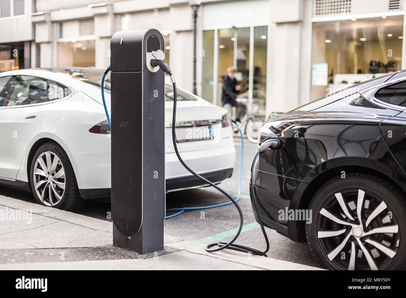 Voiture électrique moderne de charge sur la rue comme avenir de l'industrie automobile. Banque D'Images