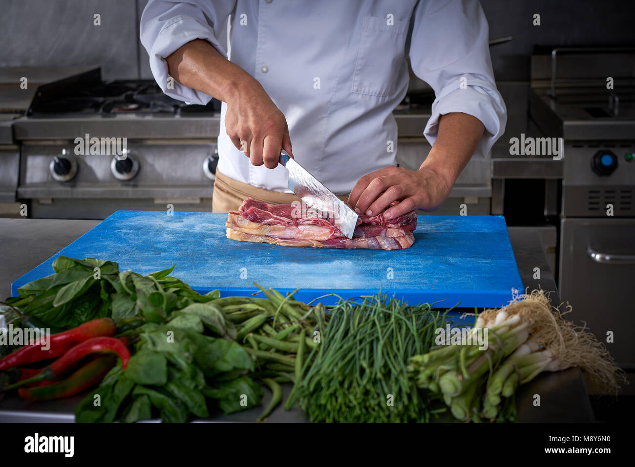 Couper la viande dans les mains du chef de cuisine restaurant en acier inoxydable Banque D'Images