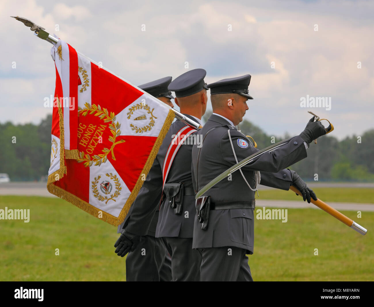 Mars soldats avec drapeau pendant 90e Jubilé de l'Armée de l'Air polonaise Academy "l'école des jeunes pygargues'. Deblin, Pologne, 20 juin 2015. Banque D'Images