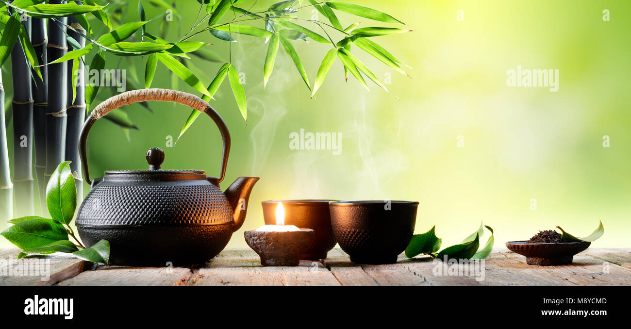 Asiatique de fer noir Théière et tasses avec la feuille de thé vert Banque D'Images
