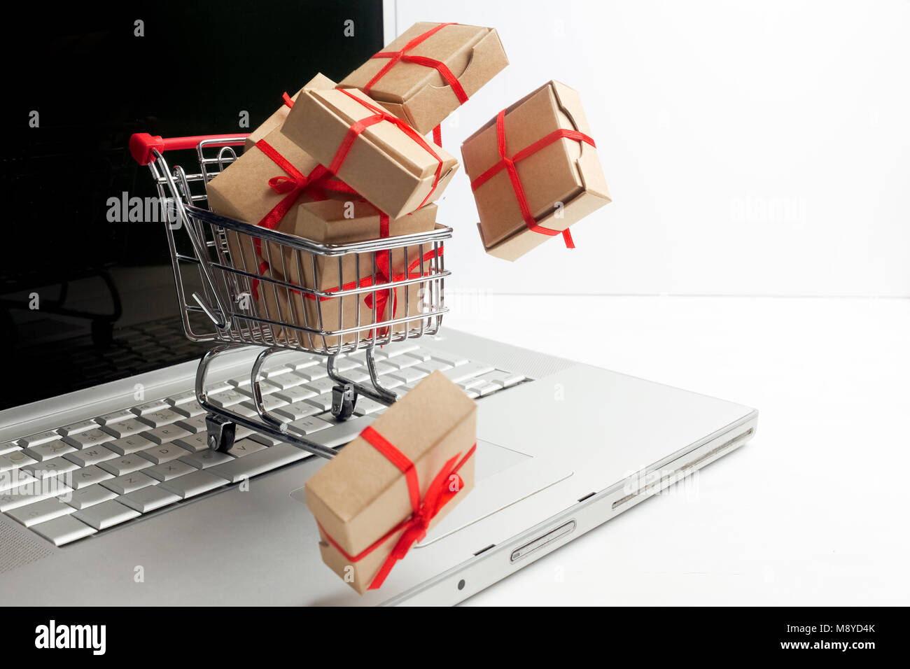Les boîtes de papier dans un panier sur un clavier d'ordinateur portable. Des idées sur l'e-commerce, une transaction d'achat ou vente de biens. Banque D'Images