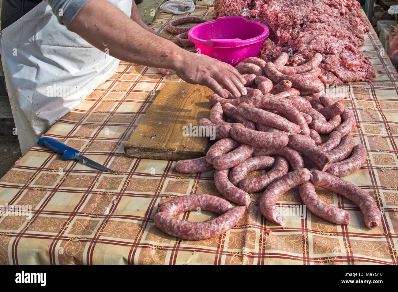 Le Boucher fait des saucisses en plein air de façon traditionnelle. Banque D'Images