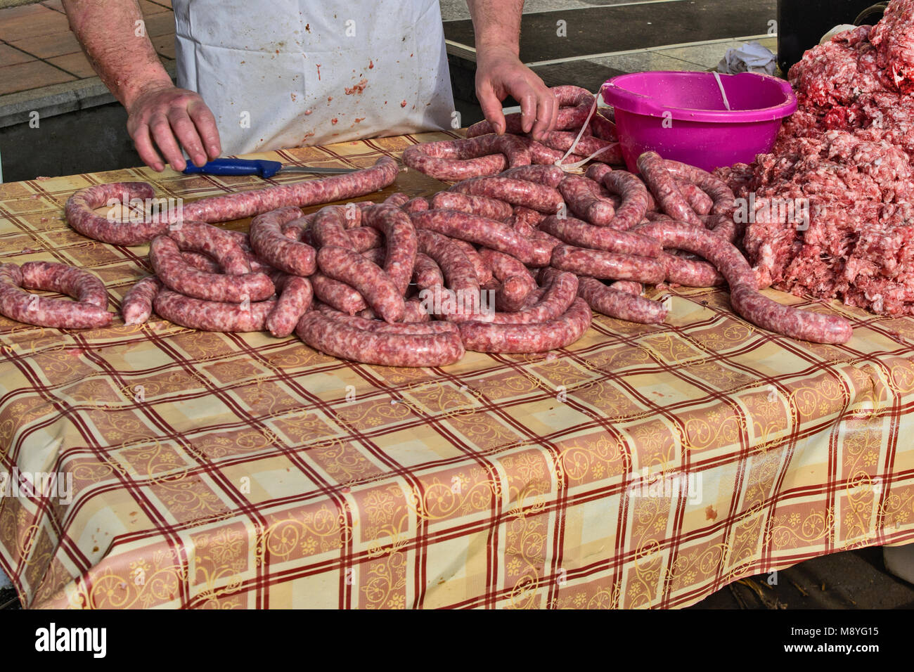 Le Boucher fait des saucisses en plein air de façon traditionnelle. Banque D'Images