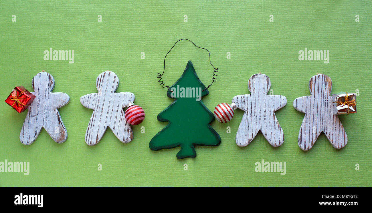 Gingerbread men découpage d'un ornement en bois d'un arbre de Noël et donner des cadeaux sur un fond de bois blanc rustique sur le dessus d'un fond vert Banque D'Images