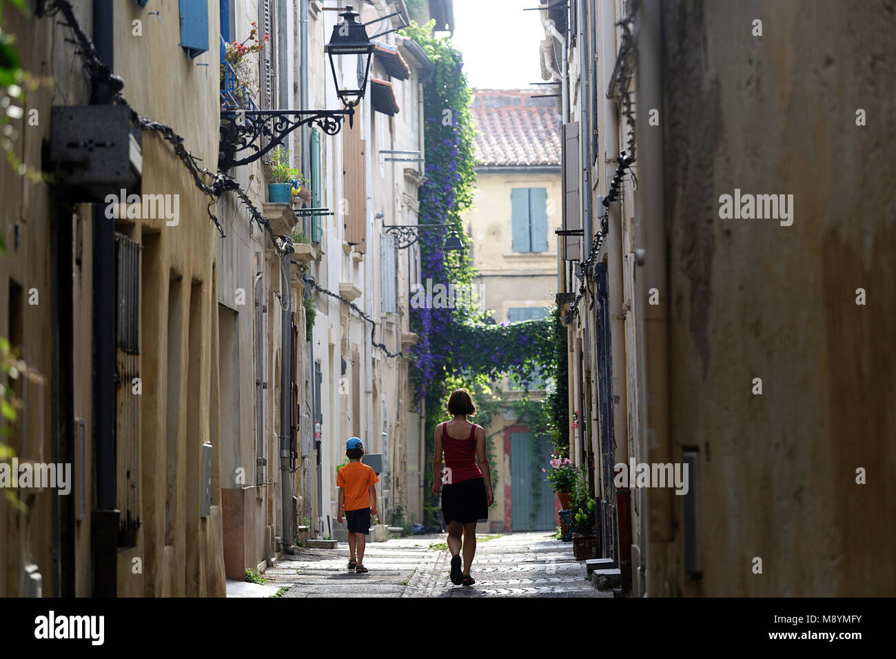 La mère et le fils marchant sur la rue pittoresque, scène de rue à Arles, Provence, France Banque D'Images
