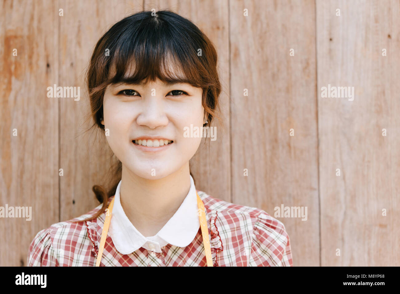 Jeune fille asiatique teen hipster tête gros plan sourire heureux vintage sur fond de bois Banque D'Images