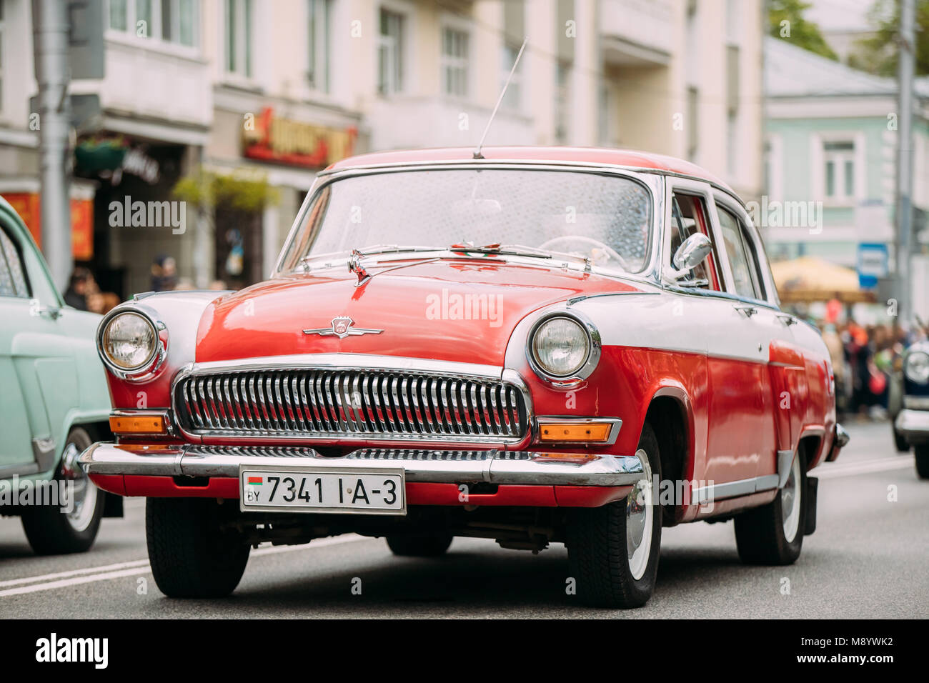 Gomel, Bélarus. Rareté automobile GAZ rétro rouge avec des personnes qui se déplacent sur la rue festive en cortège sur le défilé cérémonial Procession. Jour 9 victoire célébration M Banque D'Images