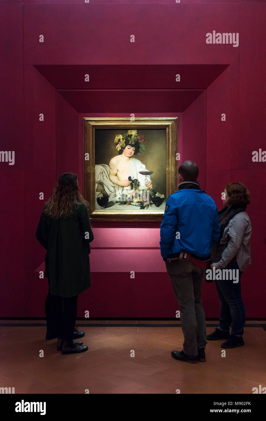 Florence. L'Italie. Galerie des Offices. Visiteurs en observant le Bacchus, tableau du Caravage (ca. 1595). Galleria degli Uffizi. Les huit chambres au premier Banque D'Images