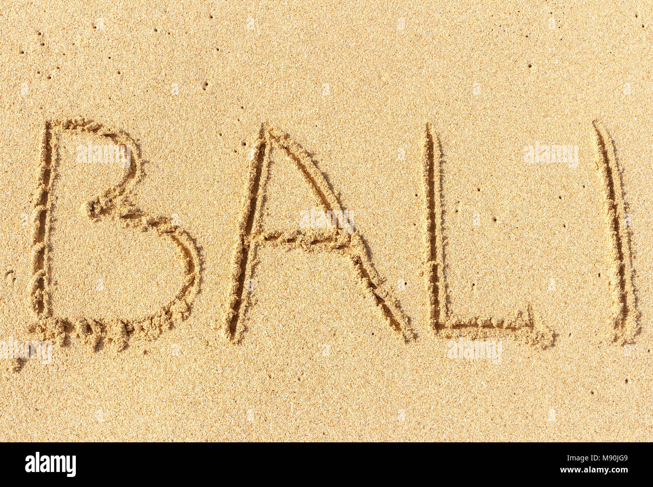 L'inscription sur le sable de Bali. Vacances, vacances à la plage. Banque D'Images