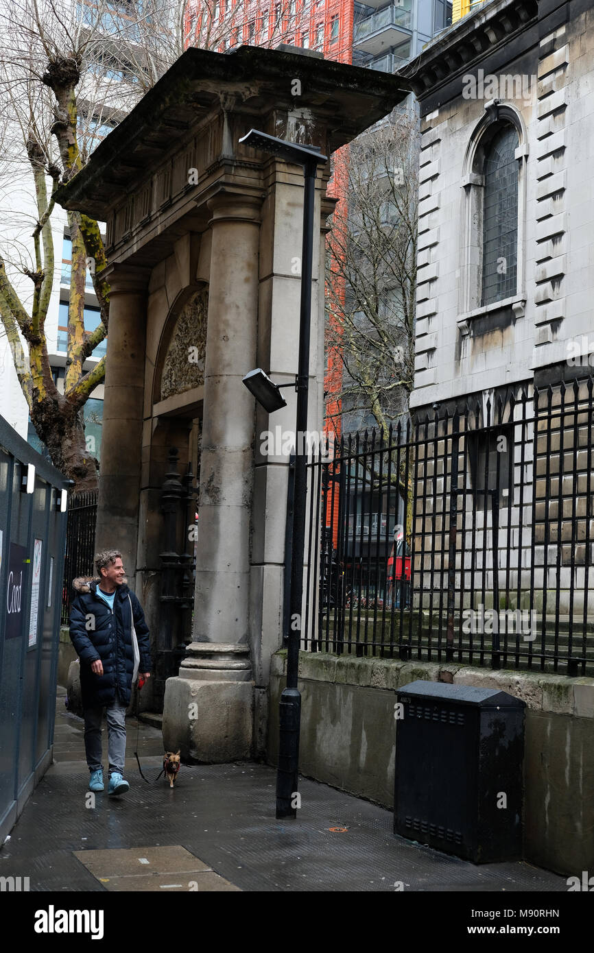 Homme marchant passé la résurrection Gate, St Giles dans les champs, Londres. Banque D'Images