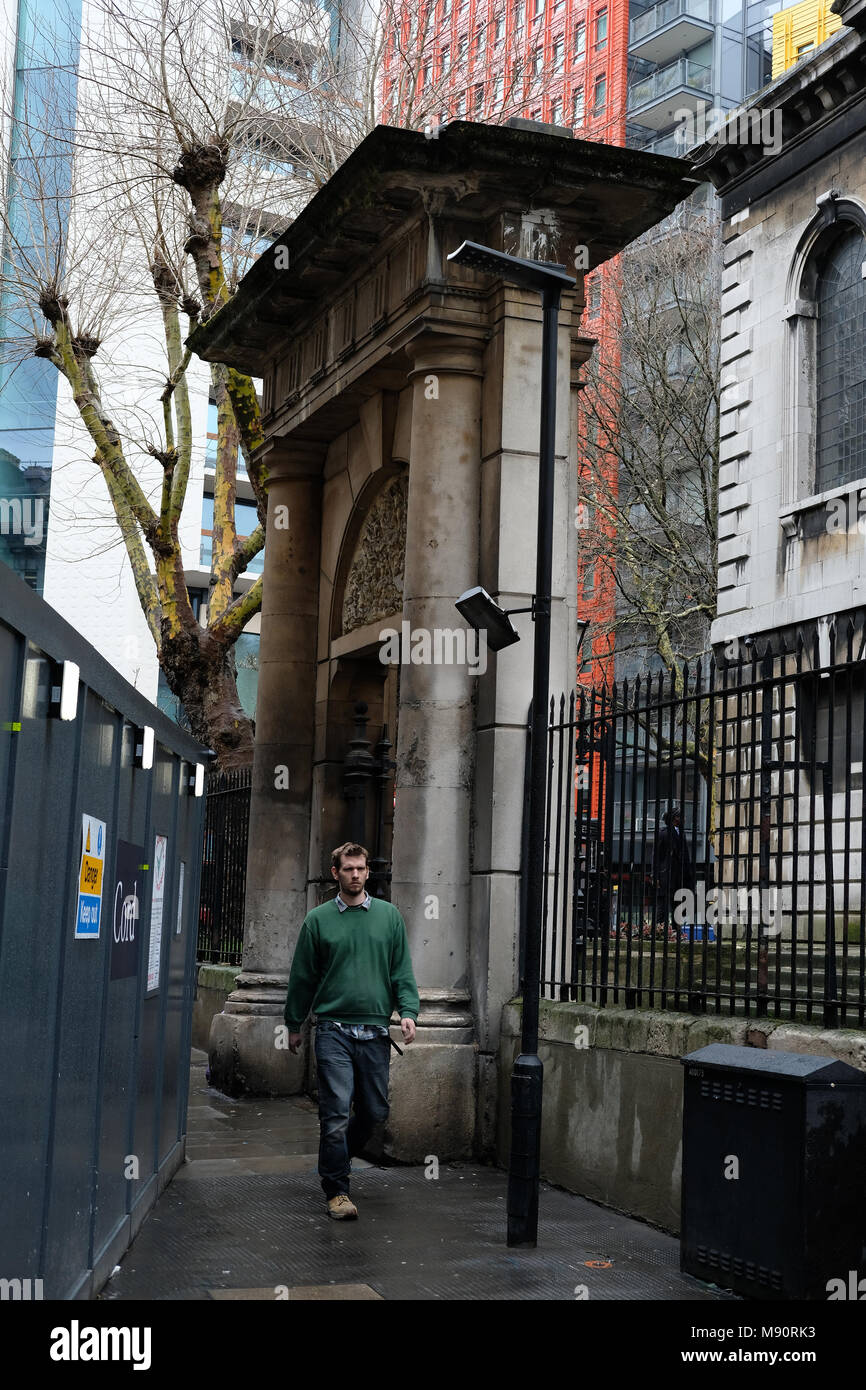 Homme marchant passé la résurrection Gate, St Giles dans les champs, Londres. Banque D'Images