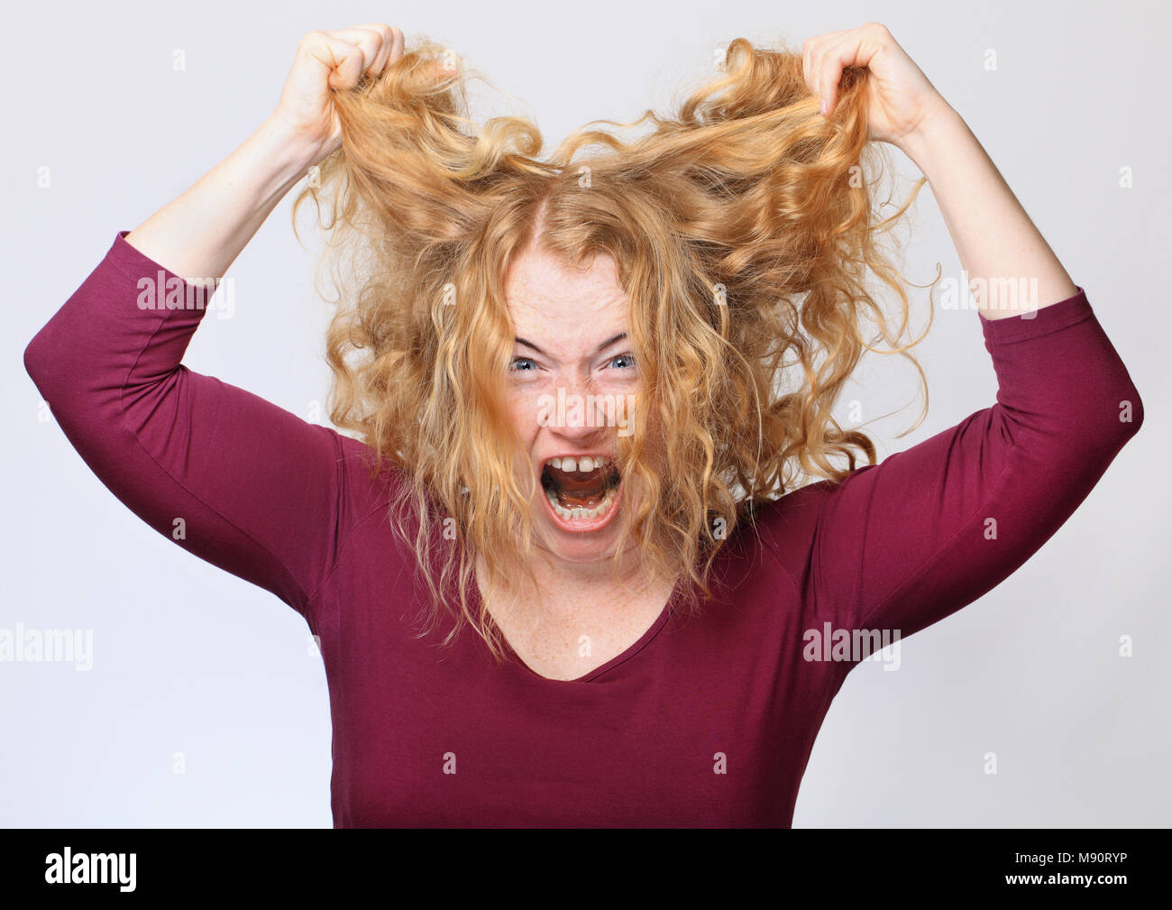 Femme criant et garder ses cheveux en place Banque D'Images