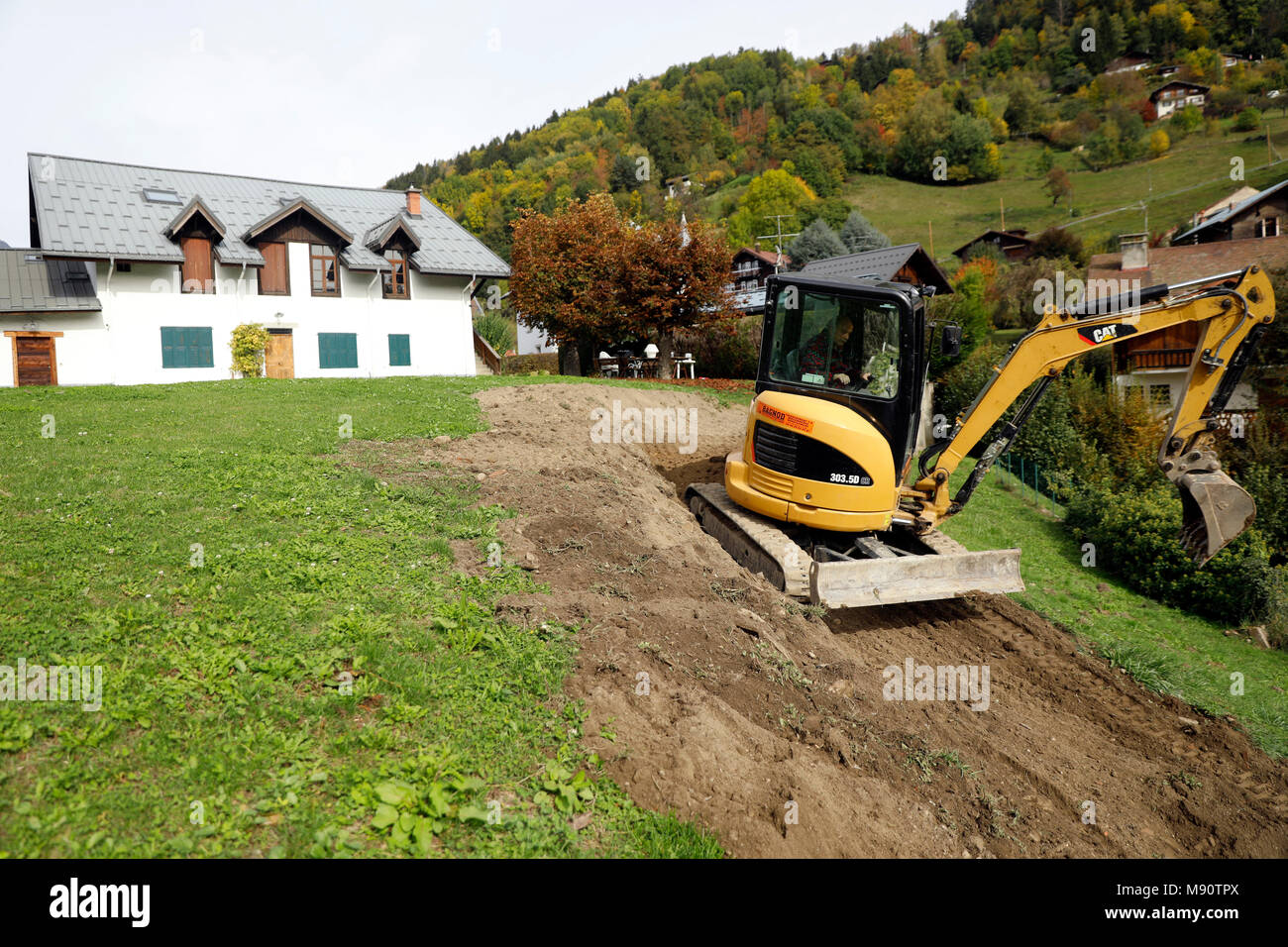 Site de construction. Mechanical digger au travail dans un jardin. Banque D'Images