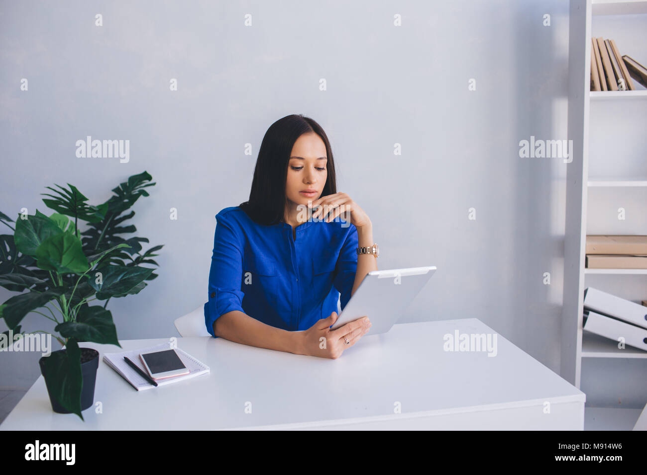 Jolie femme lire à l'aide d'une tablette Banque D'Images