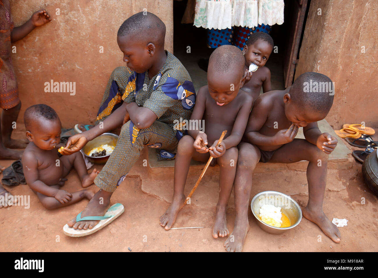 Les enfants de manger à l'extérieur de leur maison dans un village de la province du Zou, au Bénin. Banque D'Images