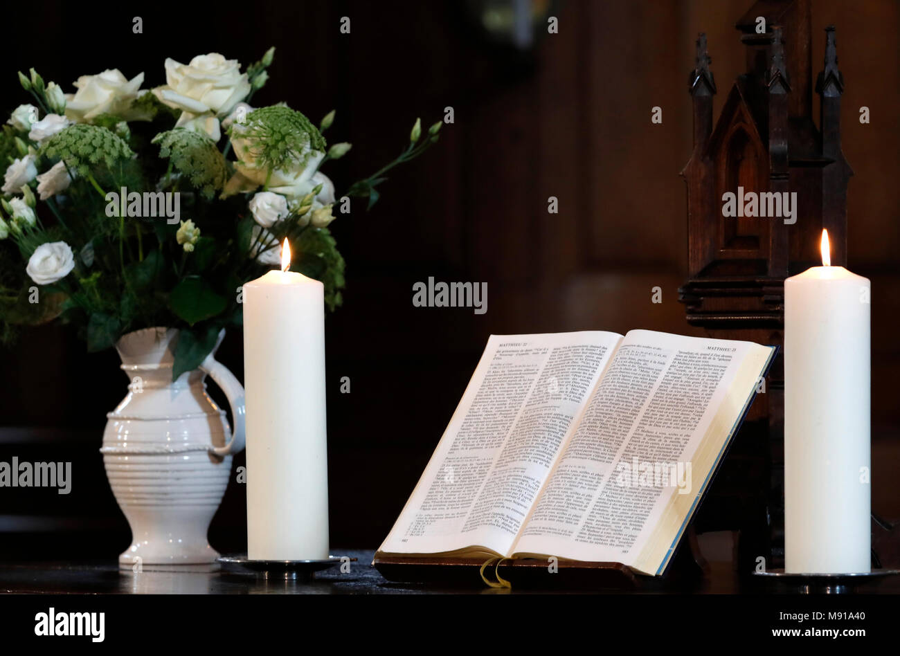 Les bougies et l'église bible ouverte sur un autel. Strasbourg. La France. Banque D'Images