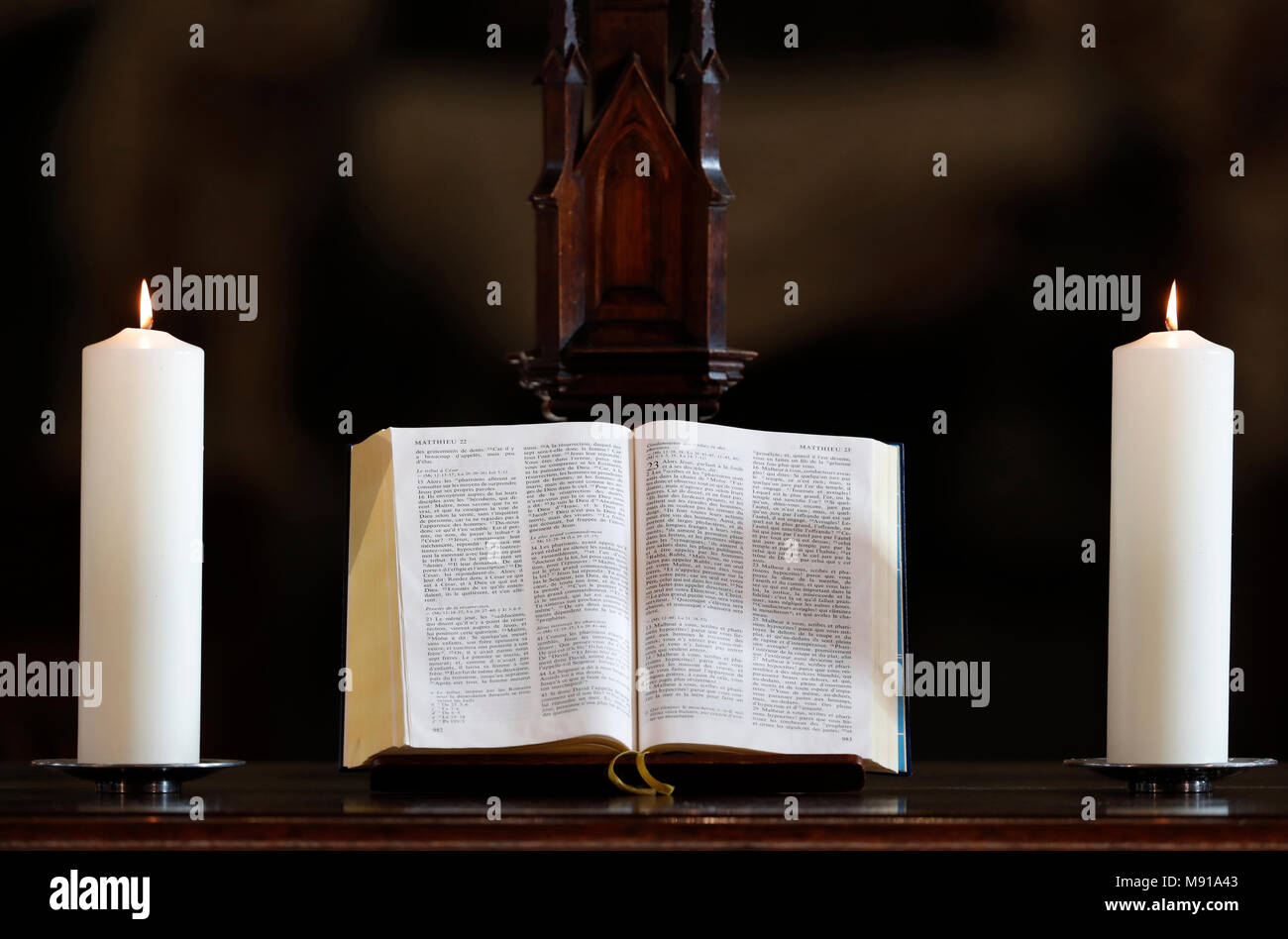 Les bougies et l'église bible ouverte sur un autel. Strasbourg. La France. Banque D'Images