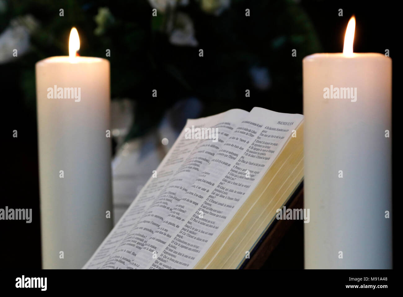 Les bougies et l'église bible ouverte sur un autel. Strasbourg. La France. Banque D'Images