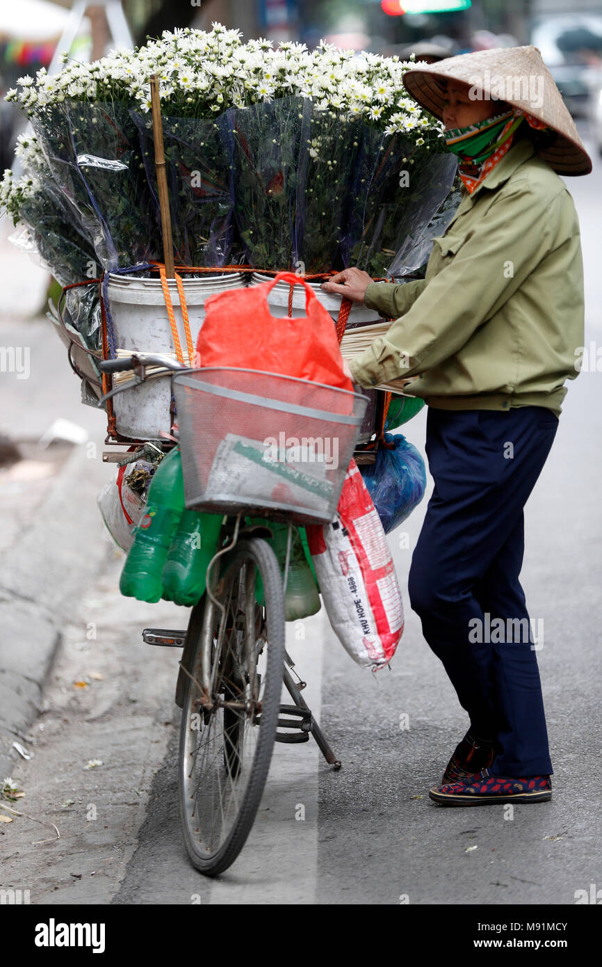 Vendeur vente de fleurs à partir de son mobile magasin de bicyclettes. Hanoi. Le Vietnam. Banque D'Images