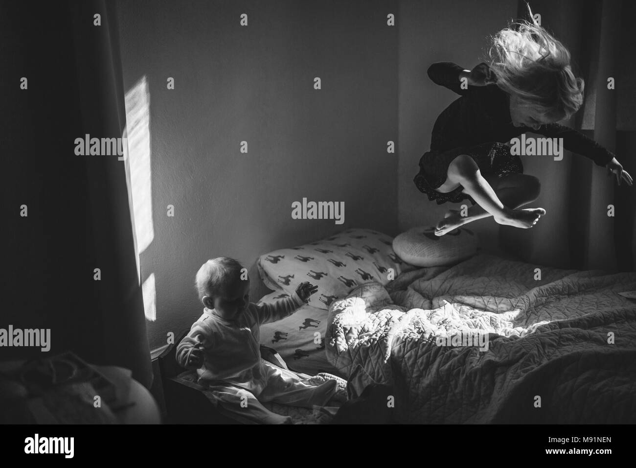 Fille saute sur lit de soleil danses bébé Banque D'Images