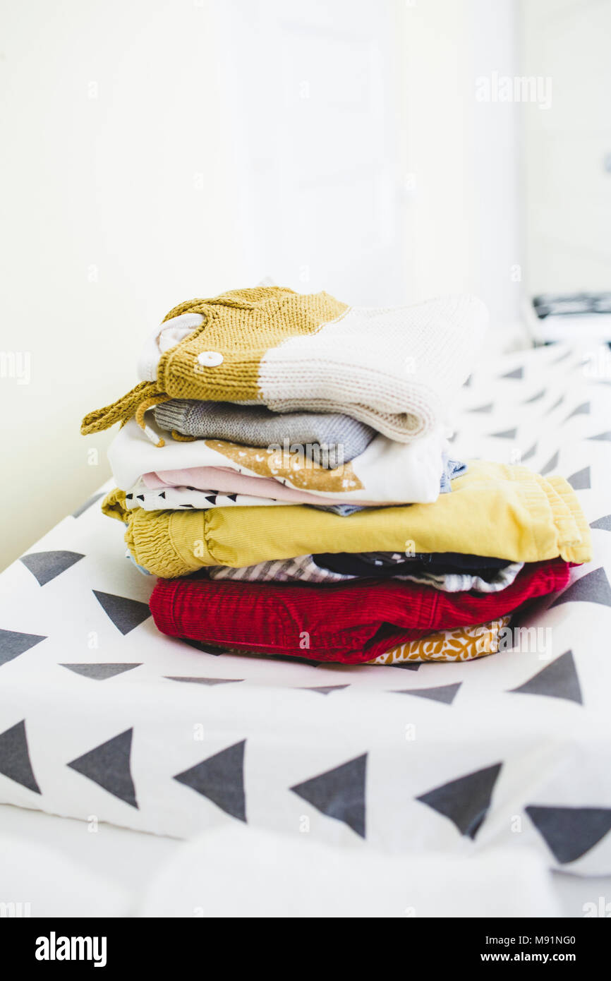 Jolie pile de vêtements de bébé moderne fond blanc Banque D'Images