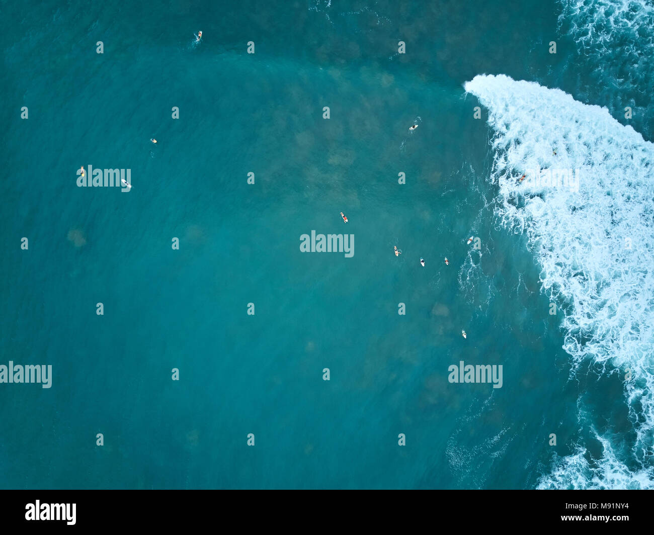 Les surfeurs en attente d'antenne d'onde vue ci-dessus sur l'eau de l'océan bleu Banque D'Images