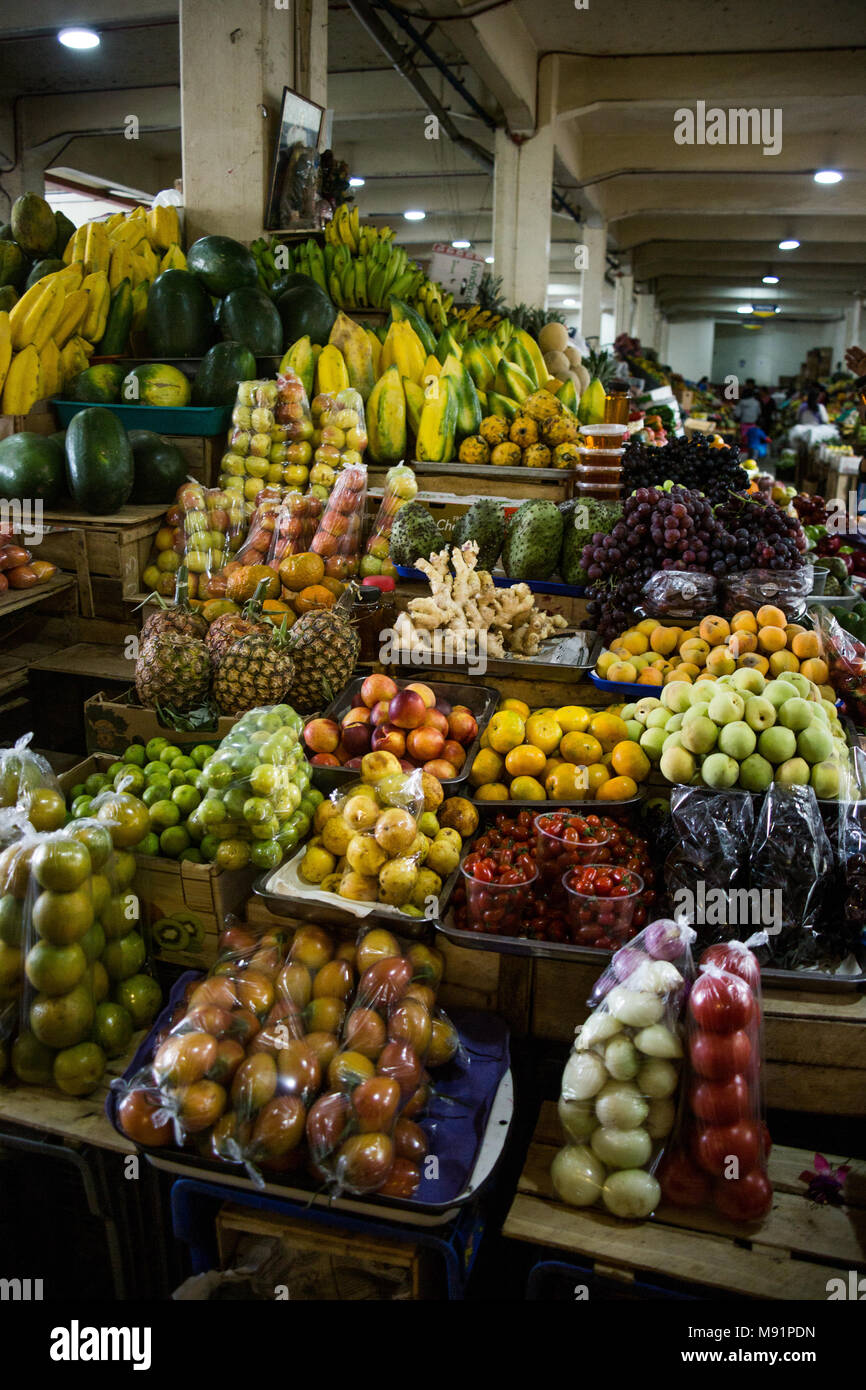 Les fruits et légumes frais emballés empilés dans une piscine marché de producteurs à Cuenca, Équateur Banque D'Images