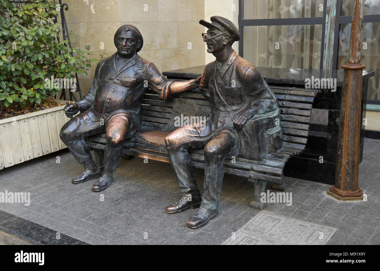 Sculpture en bronze d'un transporteur et son ami sur un banc à l'extérieur d'un restaurant en vieille ville, Tbilissi, Géorgie Banque D'Images
