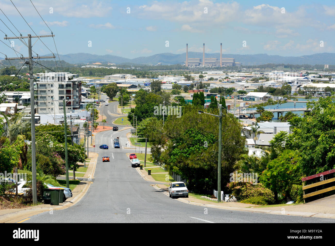 Gladstone, Queensland, Australie - Janvier 3, 2018. Vue vers le bas une rue en pente dans un quartier vallonné de Gladstone, à l'égard de la centrale, avec buildi Banque D'Images