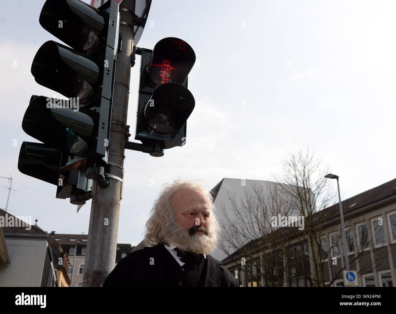 19 mars 2018, l'Allemagne, Trèves : une figure de Karl Marx se tient sous un feu rouge avec un symbole de Karl Marx. La technologie LED et des pochoirs ont été installés pour le feu de circulation à proximité du point d'être érigée la statue de Karl Marx. Photo : Harald Tittel/dpa Banque D'Images