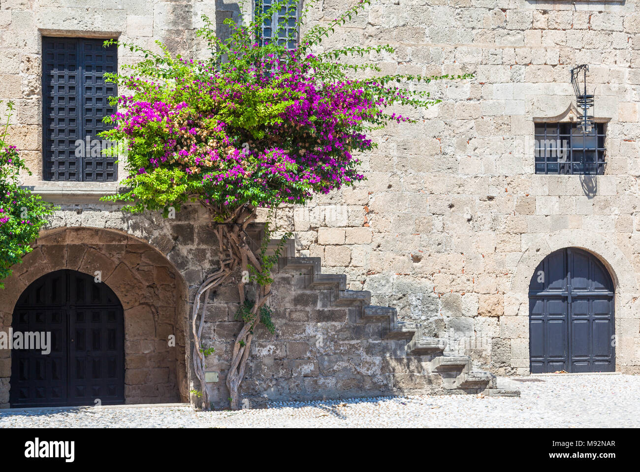 Bougainvillée violet et à l'architecture de l'Argyrokastrou square, l'île de Rhodes, Grèce Banque D'Images