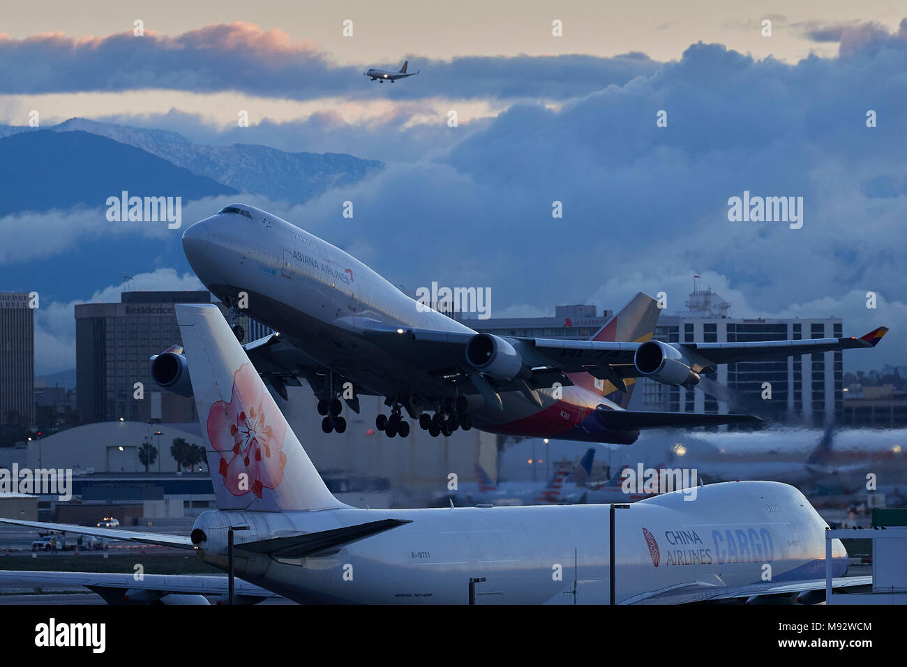 Asiana Airlines Boeing 747-400 Jet passagers décollant de l'Aéroport International de Los Angeles, LAX, à l'aube. Les nuages couvrant la ville derrière. Banque D'Images
