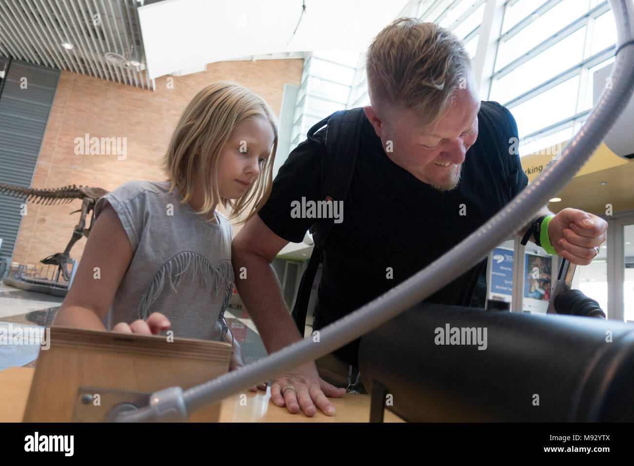 Papa essaie de montrer comment la fille pompe balle de ping-pong de lancement avec un canon d'air du Musée des sciences du Minnesota. Minneapolis Minnesota MN USA Banque D'Images