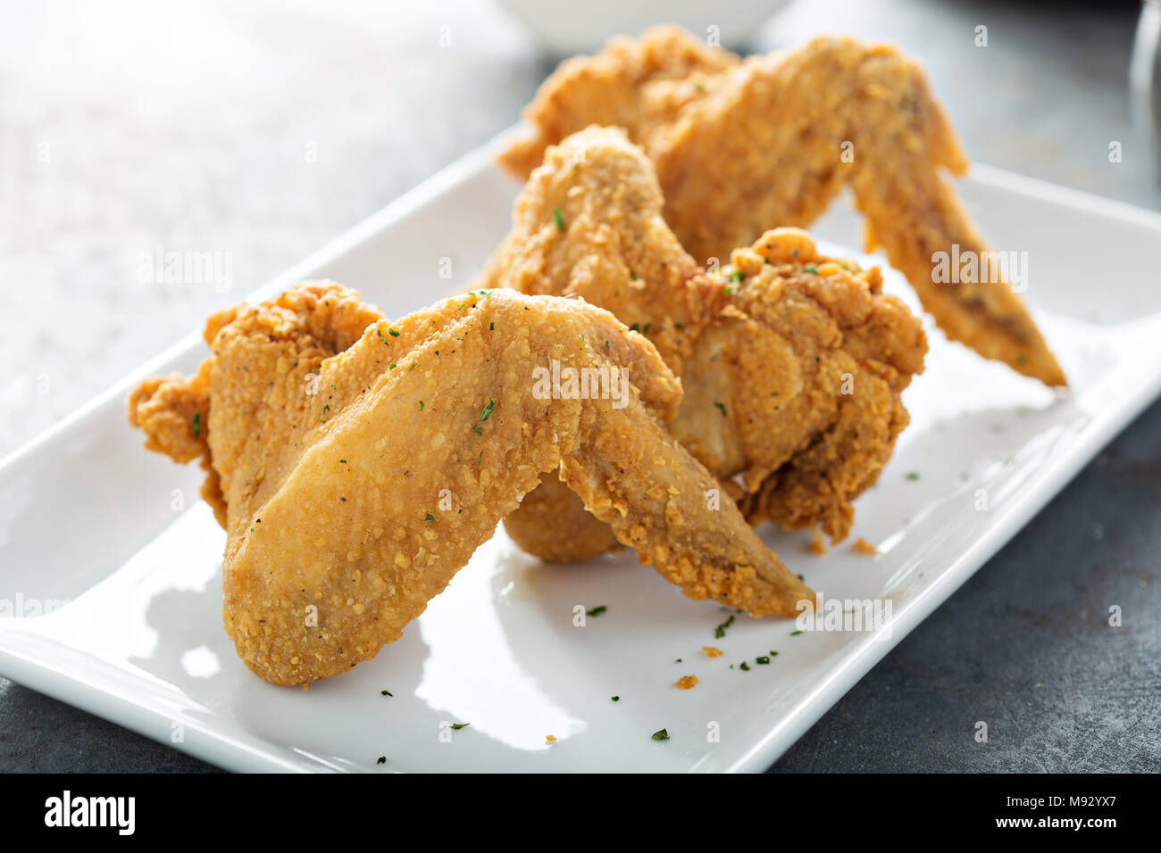 Ailes de poulet frites sur une assiette blanche Banque D'Images